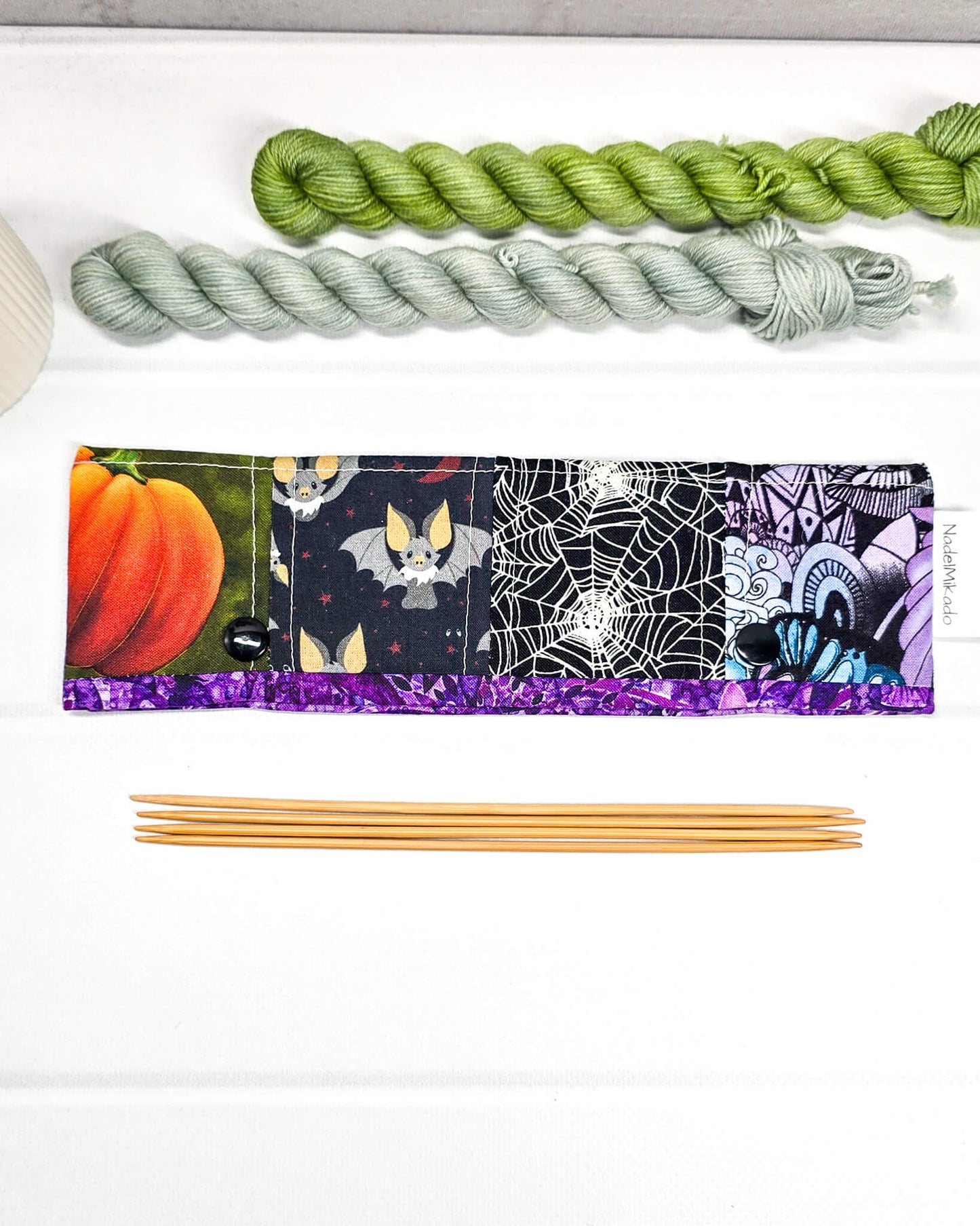 Nadelgarage für 20 cm Nadelspiele im Patchwork-Stil mit Halloween-Motiven wie schwarzen Katzen, Totenköpfen, Kürbissen und einem Vampirgnom-Design. Handgenäht in Bayern von Nadelmikado.