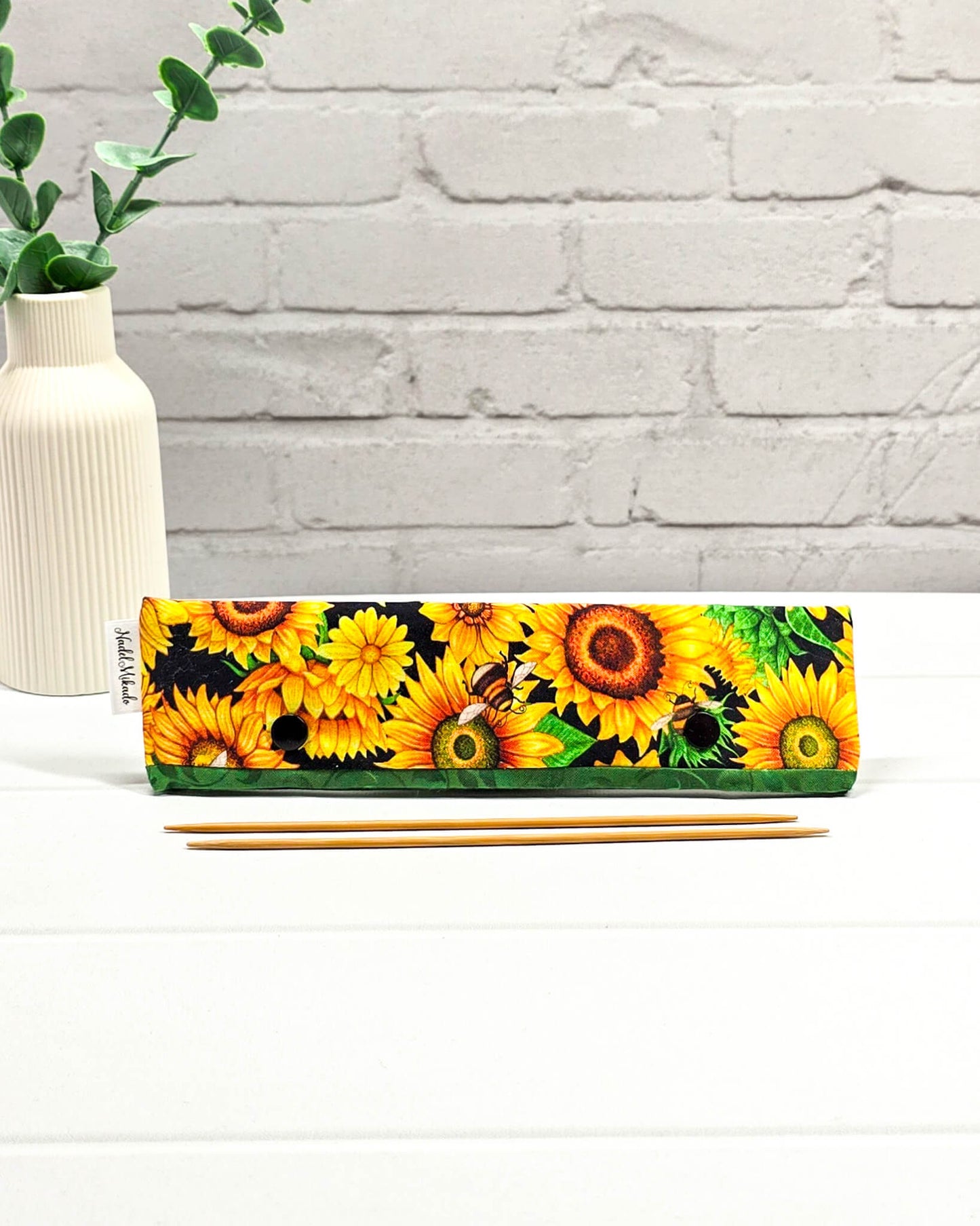 Nadelgarage für 20 cm Nadelspiele mit großen Sonnenblumen, kleinen Bienen und einer grünen Bordüre mit schwarzen Druckknöpfen. Handgenäht in Bayern von Nadelmikado