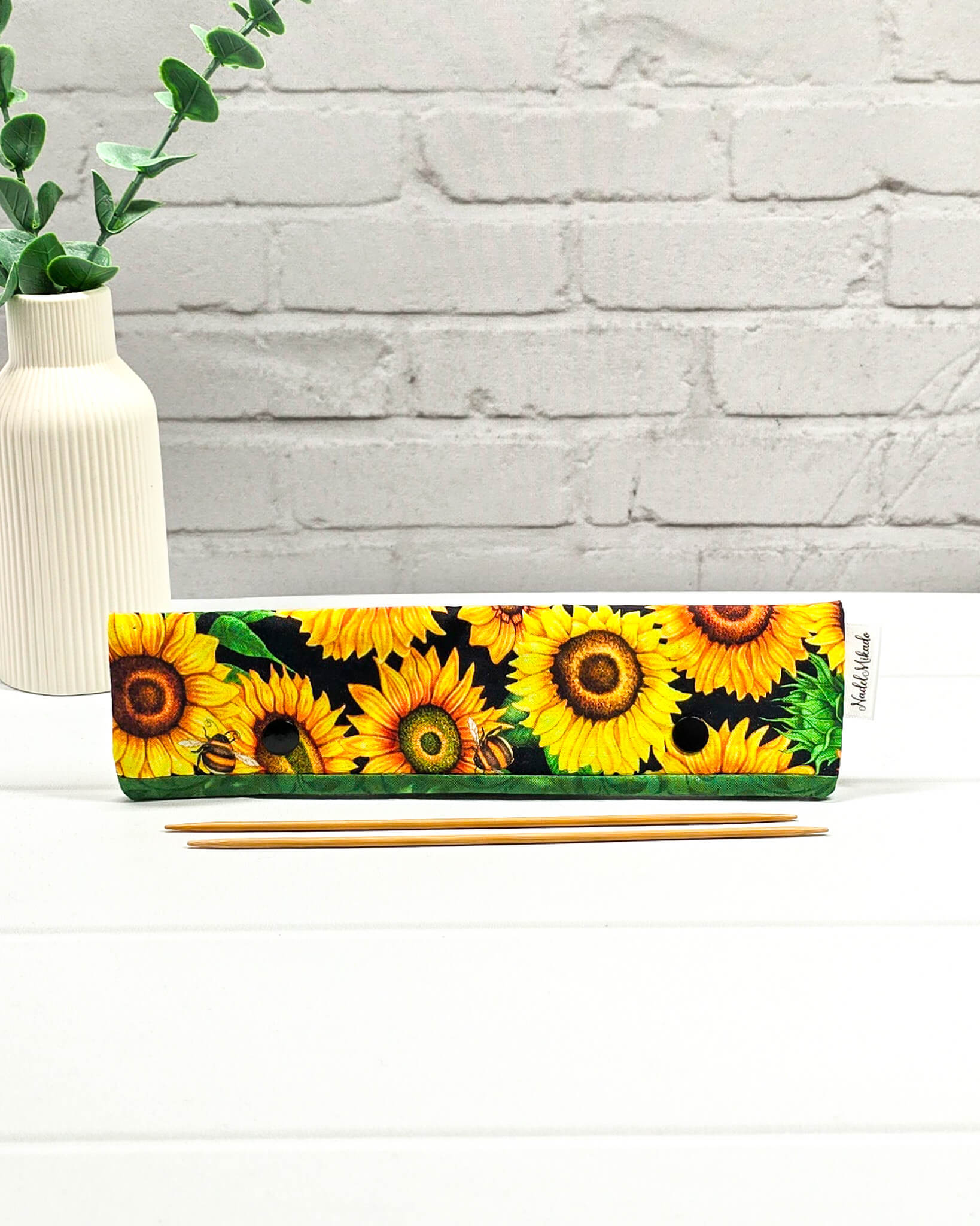 Nadelgarage für 20 cm Nadelspiele mit großen Sonnenblumen, kleinen Bienen und einer grünen Bordüre mit schwarzen Druckknöpfen. Handgenäht in Bayern von Nadelmikado