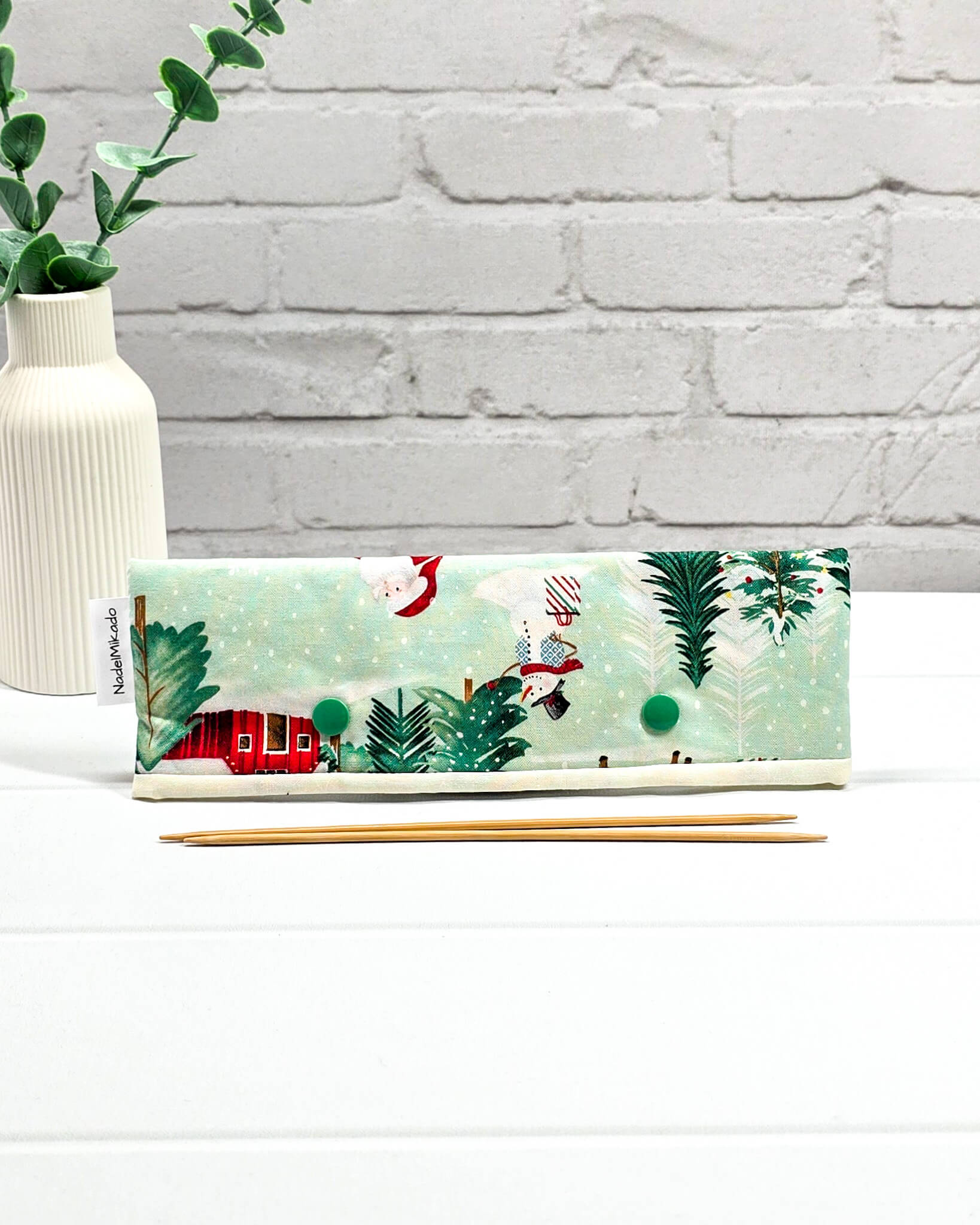 Nadelgarage für 20 cm Nadelspiele mit Motiven vom Weihnachtsmann, Schlitten und Tannenbäumen auf mintgrünem Stoff mit grünen Druckknöpfen. Handgenäht in Bayern von Nadelmikado