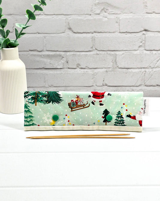 Nadelgarage für 20 cm Nadelspiele mit Motiven vom Weihnachtsmann, Schlitten und Tannenbäumen auf mintgrünem Stoff mit grünen Druckknöpfen. Handgenäht in Bayern von Nadelmikado