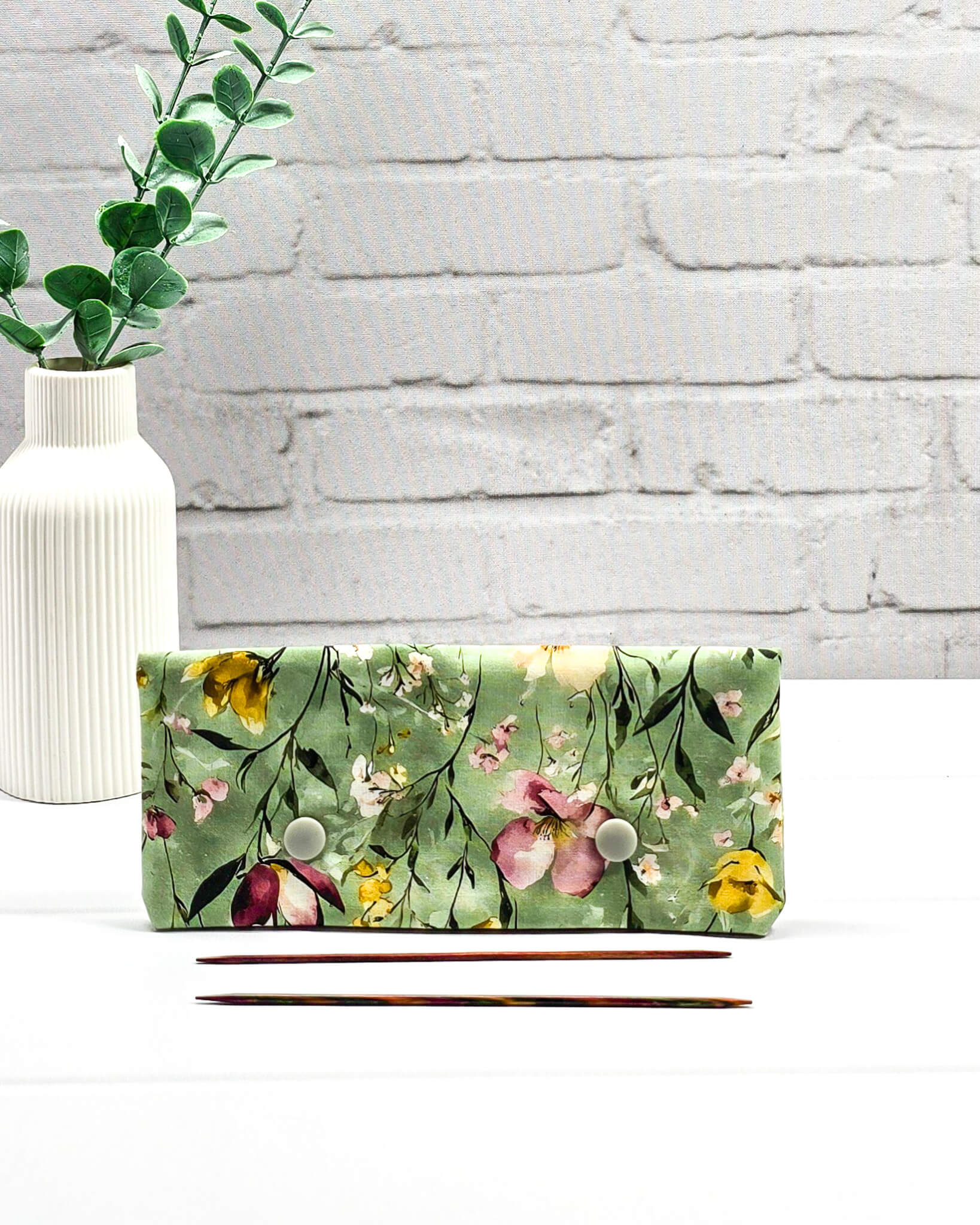 Nadelgarage für 15cm Nadelspiele mit buntem Wildblumenmotiv auf salbeigrünem Grund und zwei hellgrauen Druckknöpfen. Handgenäht in Bayern von Nadelmikado.