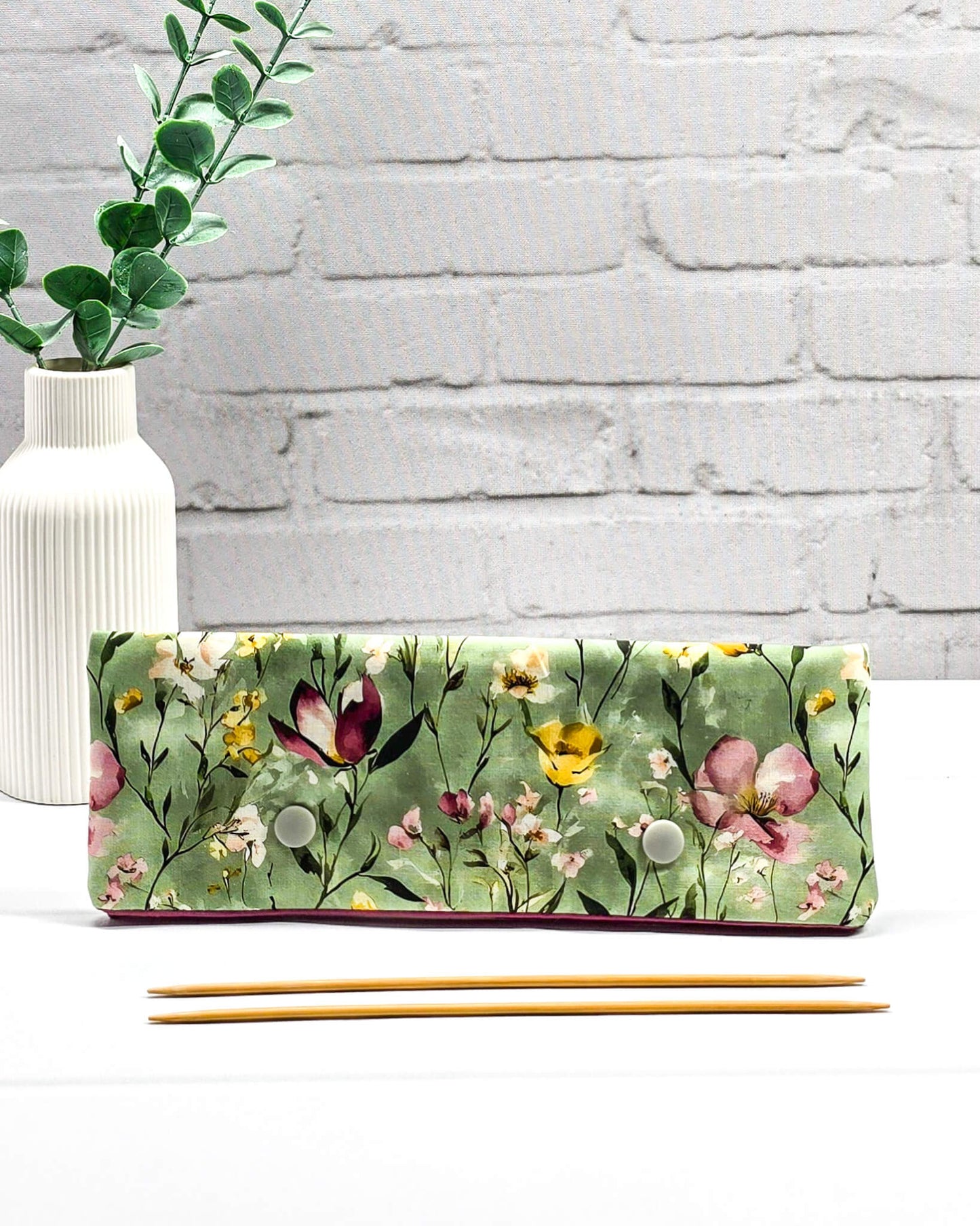 Lange Nadelgarage für 20cm Nadelspiele mit buntem Wildblumenmotiv auf salbeigrünem Grund und zwei hellgrauen Druckknöpfen. Handgenäht in Bayern von Nadelmikado.