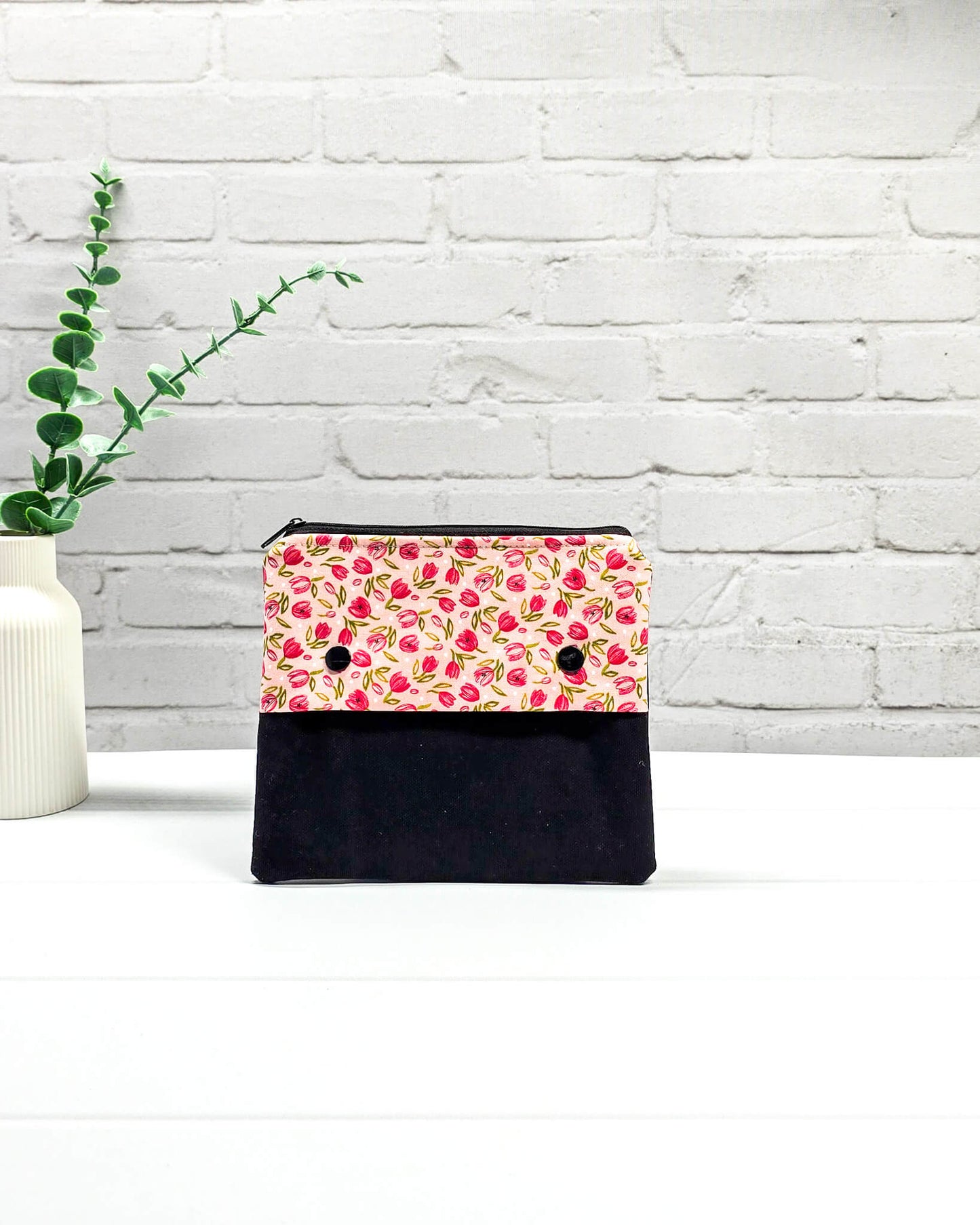 Nadelgarage Plus für 15 cm lange Nadelspiele mit einem Muster aus kleinen pinken Tulpen, schwarzer Klappe und zwei Druckknöpfen. Handgenäht in Bayern von Nadelmikado. 