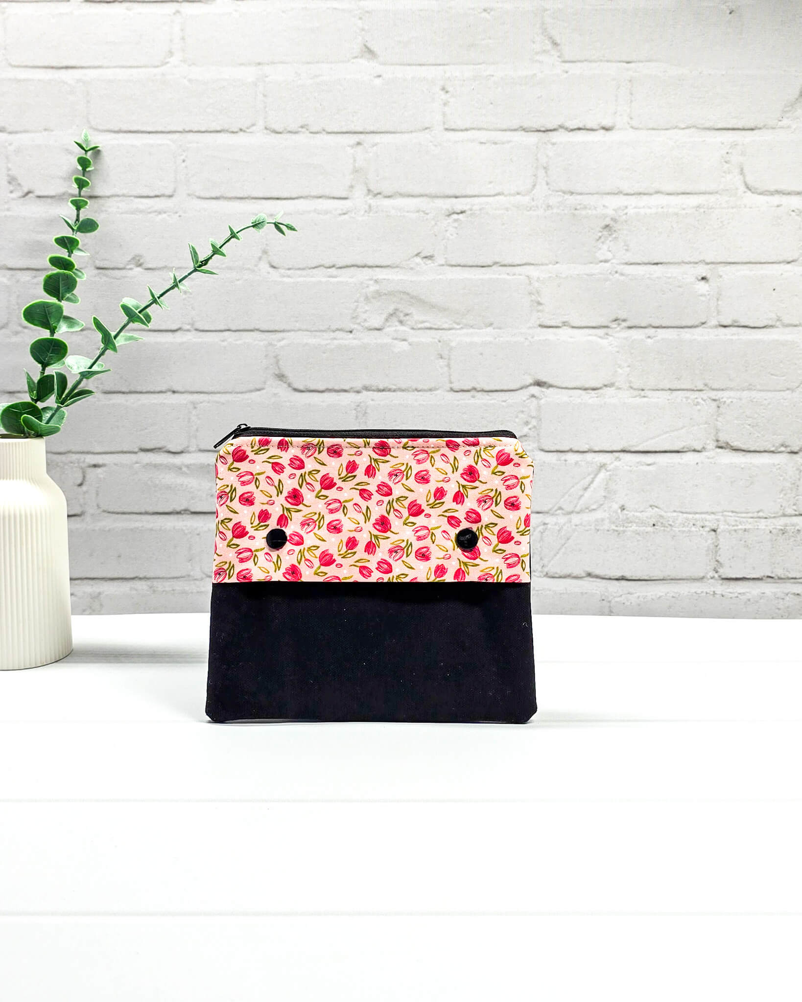 Nadelgarage Plus für 15 cm lange Nadelspiele mit einem Muster aus kleinen pinken Tulpen, schwarzer Klappe und zwei Druckknöpfen. Handgenäht in Bayern von Nadelmikado. 