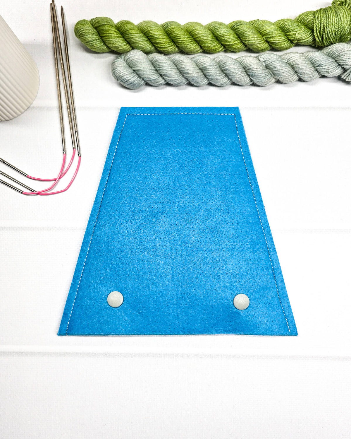 Nadelgarage für Trio-Stricknadeln aus leuchtend blauem Filz mit zwei hellen Druckknöpfen und abgesteppten Rändern. Handgenäht in Bayern von Nadelmikado.