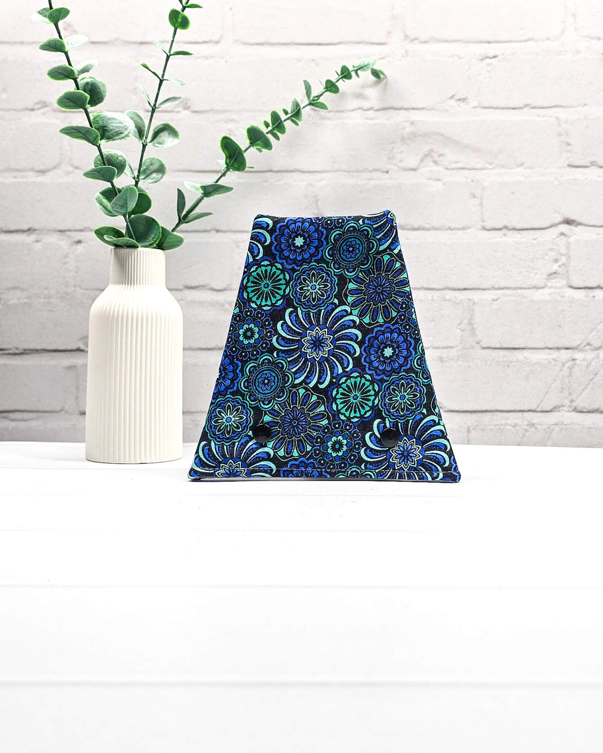Nadelgarage für Trio-Stricknadeln mit floralen Ornamenten in Blau, Türkis und Schwarz sowie zwei schwarzen Druckknöpfen. Handgenäht in Bayern von Nadelmikado.