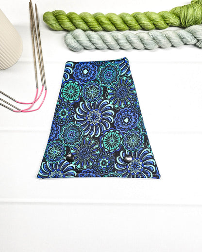 Nadelgarage für Trio-Stricknadeln mit floralen Ornamenten in Blau, Türkis und Schwarz sowie zwei schwarzen Druckknöpfen. Handgenäht in Bayern von Nadelmikado.