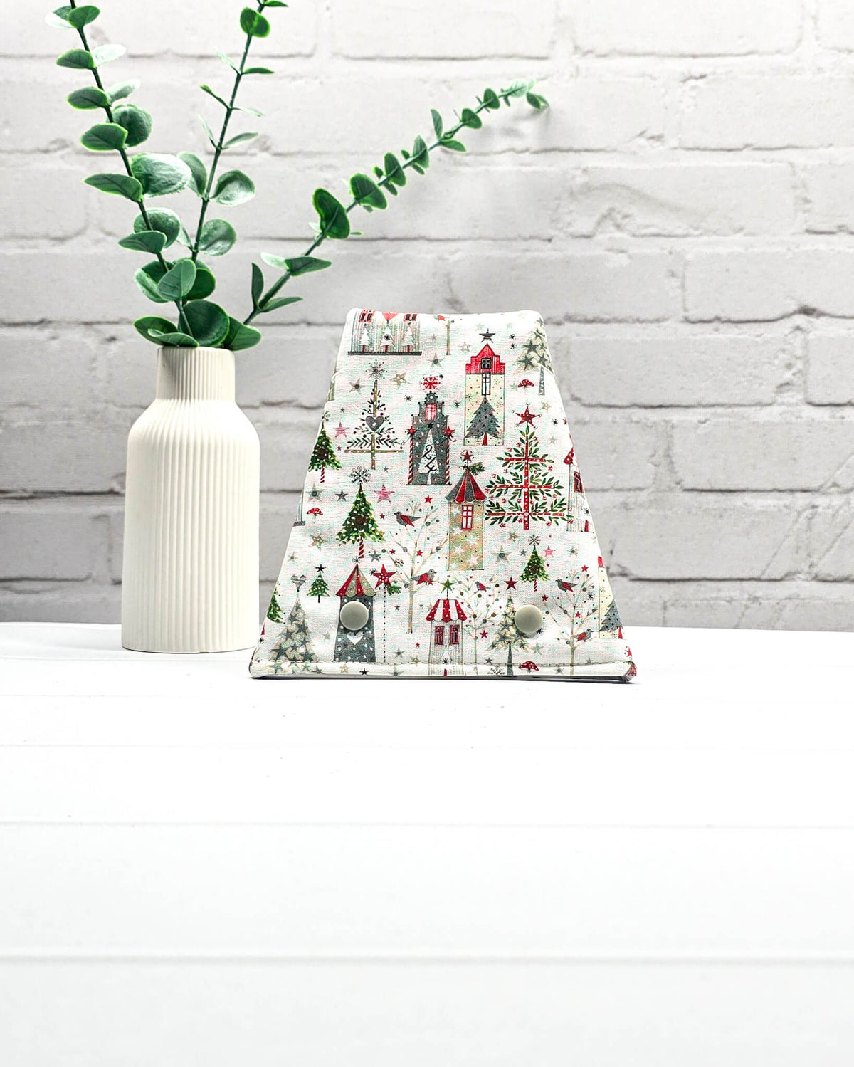 Nadelgarage für Trio-Stricknadeln mit weihnachtlichen Häusern, Tannenbäumen und Sternen auf weißem Stoff und zwei Druckknöpfen. Handgenäht in Bayern von Nadelmikado.