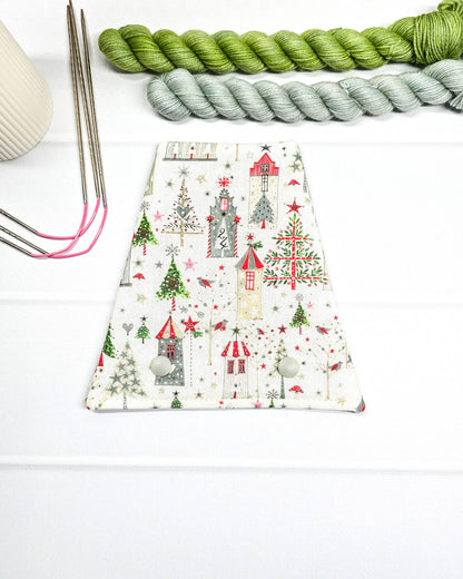 Nadelgarage für Trio-Stricknadeln mit weihnachtlichen Häusern, Tannenbäumen und Sternen auf weißem Stoff und zwei Druckknöpfen. Handgenäht in Bayern von Nadelmikado.
