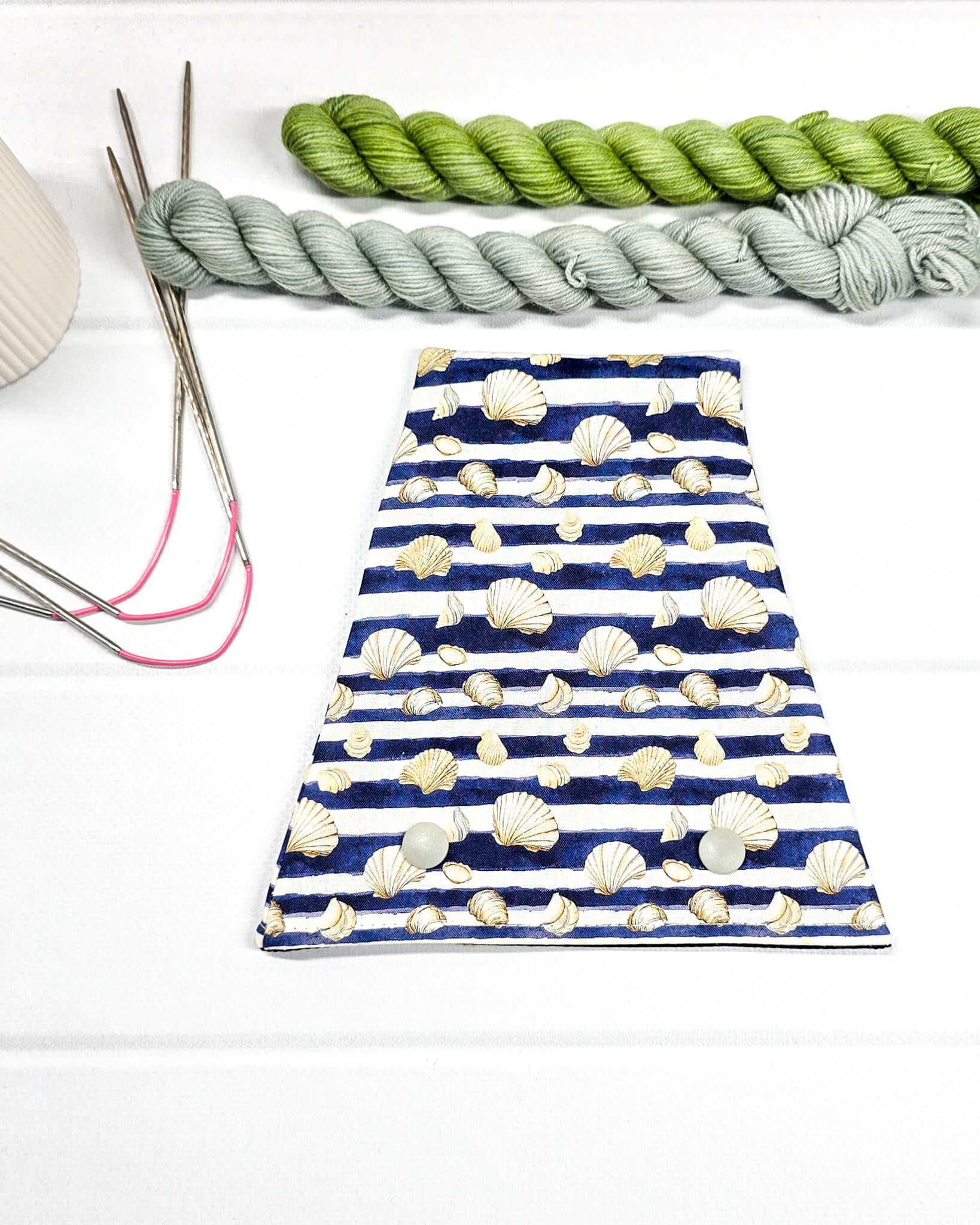 Nadelgarage für Trios aus blau-weiß gestreiftem Stoff mit Muschelmotiven und zwei Druckknöpfen. Handgenäht in Bayern von Nadelmikado. 