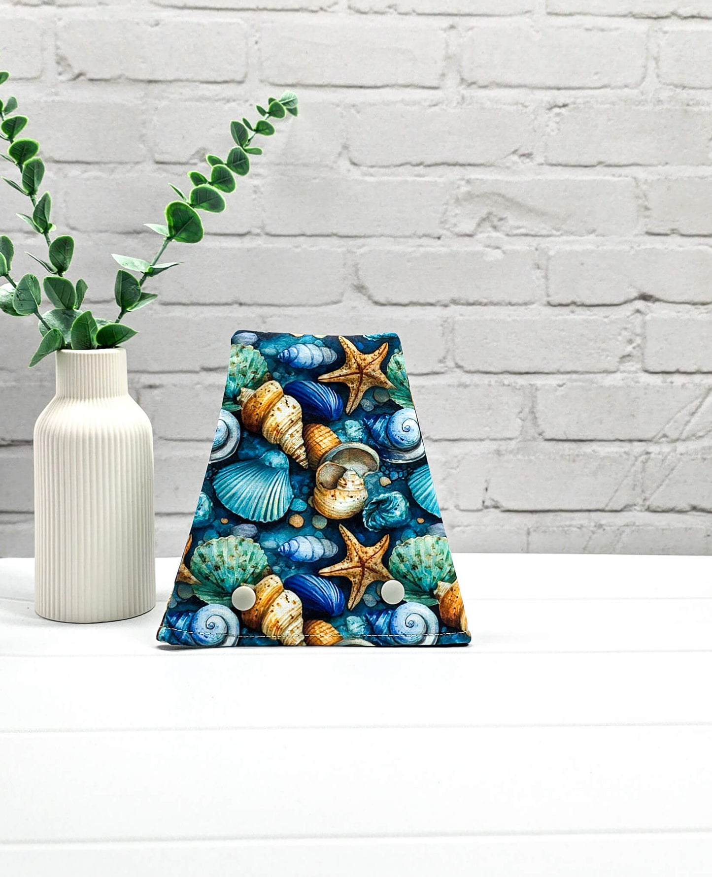 Nadelgarage für Trios aus buntem Stoff mit detaillierten Seesternen und Muscheln in Blau und Türkis sowie zwei hellen Druckknöpfen. Handgenäht in Bayern von Nadelmikado. 