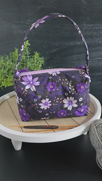 Video zur Projekttasche „Wildflocke“ – lila Handarbeitstasche mit Blumenmuster für Strickprojekte unterwegs.