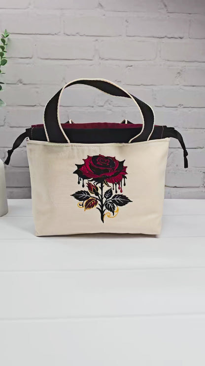 Projekttasche Alva S aus hellem Canvas mit gestickter Gothic Rose, schwarzen Henkeln und Kordelzug. Handgenäht in Bayern von Nadelmikado.