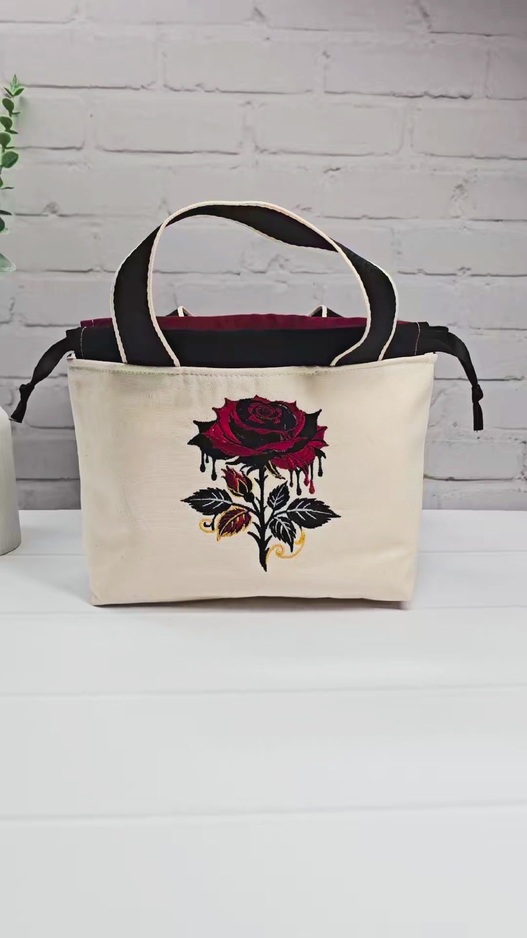 Projekttasche Alva S aus hellem Canvas mit gestickter Gothic Rose, schwarzen Henkeln und Kordelzug. Handgenäht in Bayern von Nadelmikado.
