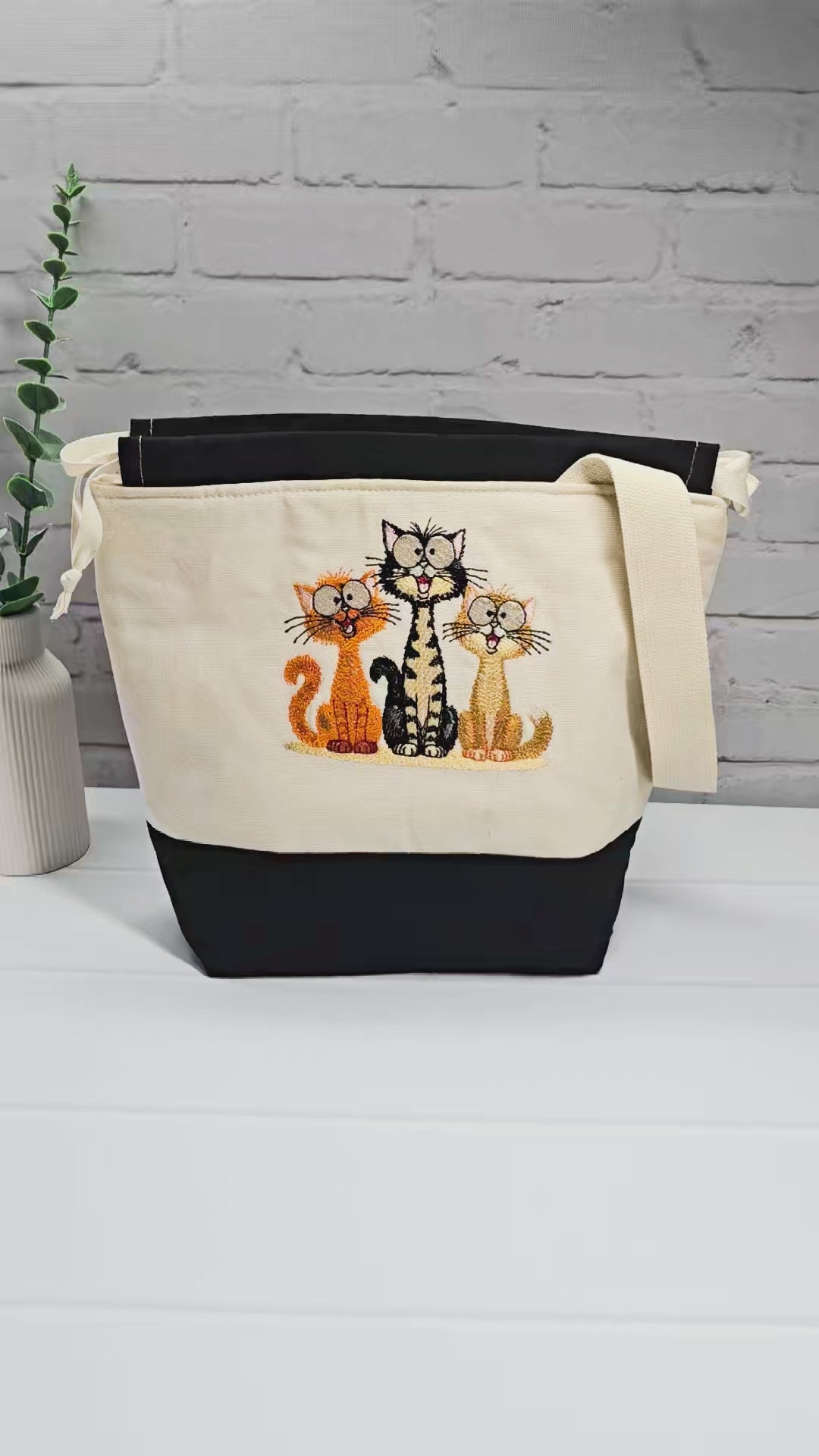 Projekttasche Tuva M aus hellem Canvas und Schwarz mit gesticktem lustigen Katzen Trio und Kordelzugverschluss. Handgenäht in Bayern von Nadelmikado.