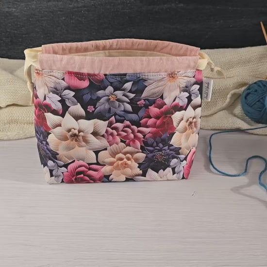 Florale Stricktasche auf weißem Hintergrund, ideal für organisierte und stilvolle Handarbeitsprojekte.