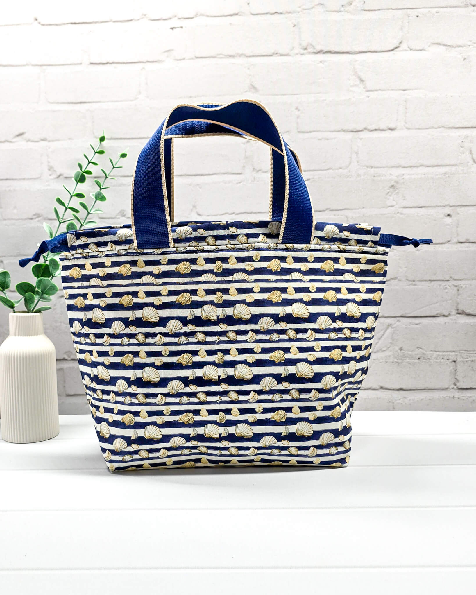Mittlere Projekttasche Alva M im gestreiften Marine-Look mit Muscheln, zwei Henkeln und Kordelzug. Handgenäht in Bayern von Nadelmikado.
