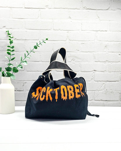 Bestickter Projektbeutel Alva S aus schwarzem Canvas mit orangefarbenem Socktober-Schriftzug, handgenäht in Bayern von NadelMikado