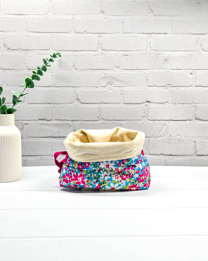 Projektbeutel Lyra mit pinken und weißen Blumen auf türkisfarbenem Grund und mit pinkem Kordelzug. Handgenäht in Bayern von Nadelmikado 