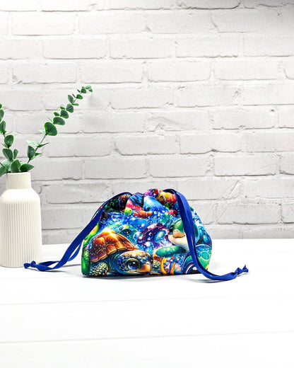 Projektbeutel Lyra mit einem bunten Motiv aus Meeresschildkröten und Fischen unter Wasser sowie blauem Kordelzug. Handgenäht in Bayern von Nadelmikado. 