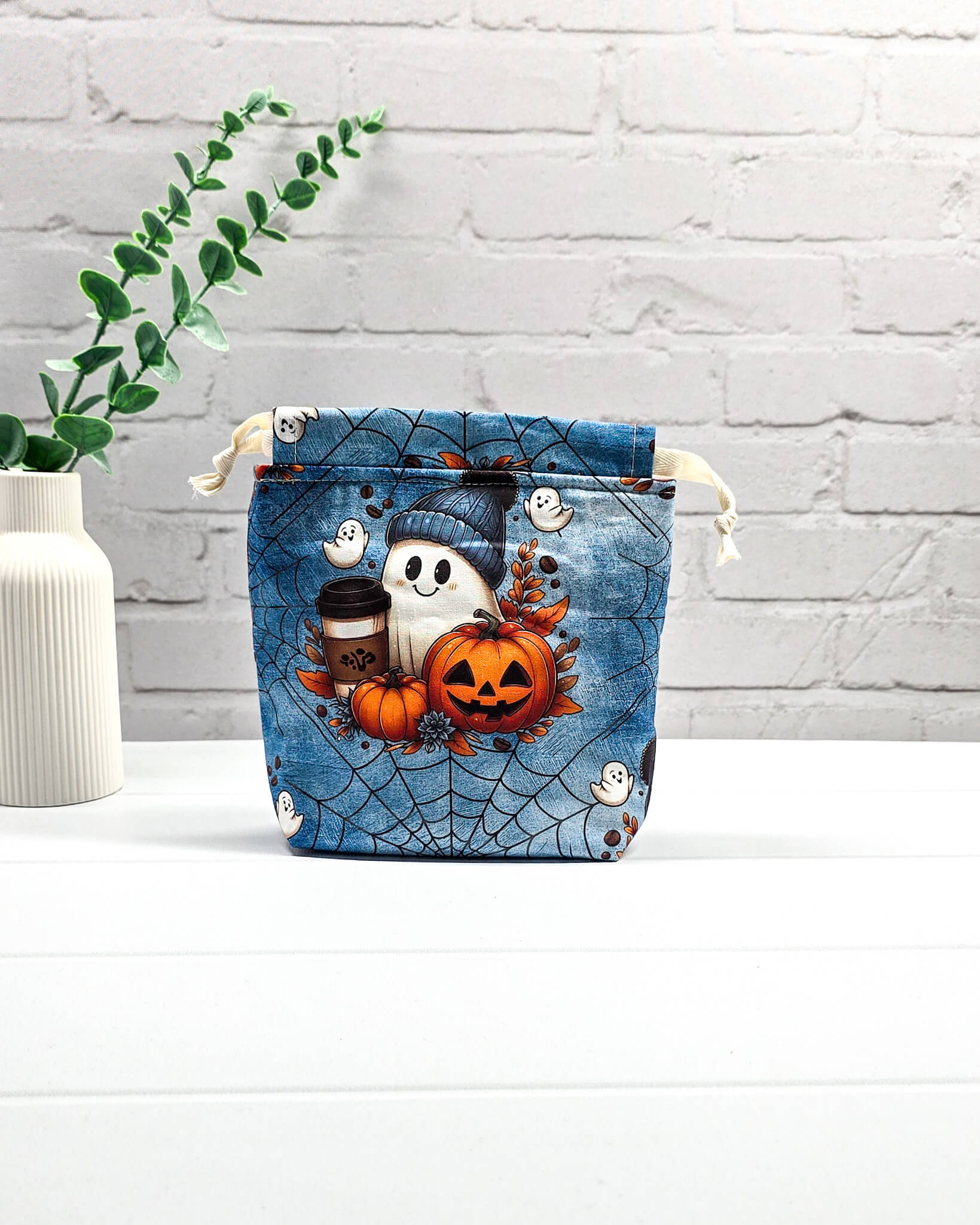 Kleiner Projektbeutel Tindra XS mit Halloween-Motiv aus Geistern, Kürbissen und Spinnennetzen auf blauem Stoff, handgenäht in Bayern von NadelMikado