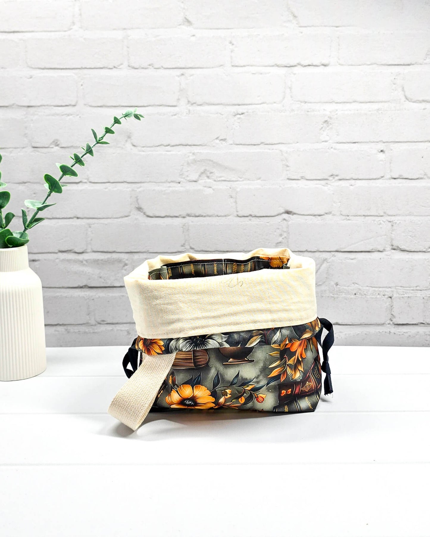 Projekttasche Tuva S mit Vintage-Büchern und floralen Motiven auf dunklem Stoff für Socken- oder Mützenprojekte - handgenäht in Bayern von Nadelmikado