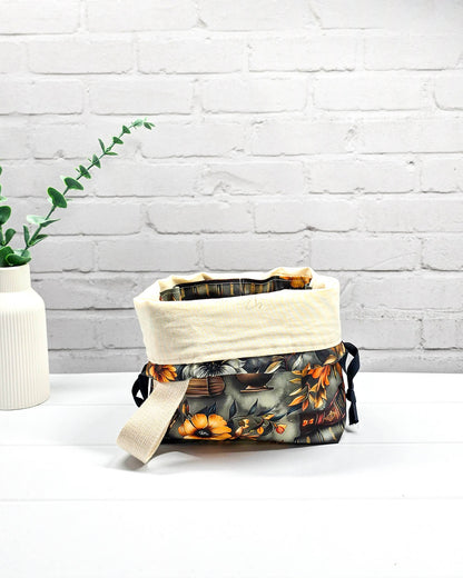 Projekttasche Tuva S mit Vintage-Büchern und floralen Motiven auf dunklem Stoff für Socken- oder Mützenprojekte - handgenäht in Bayern von Nadelmikado