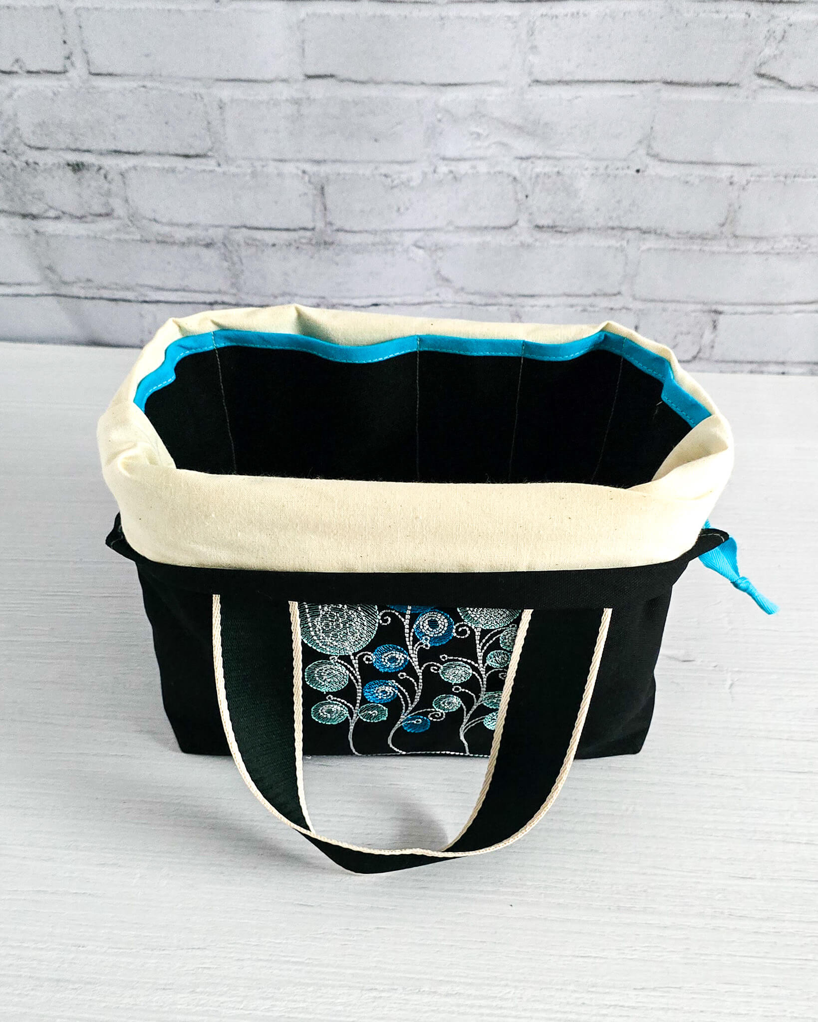 Projekttasche Alva M mit gestickten Blüten auf dunklem Canvas, handgenäht in Bayern von Nadelmikado