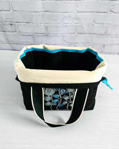 Projekttasche Alva M mit gestickten Blüten auf dunklem Canvas, handgenäht in Bayern von Nadelmikado