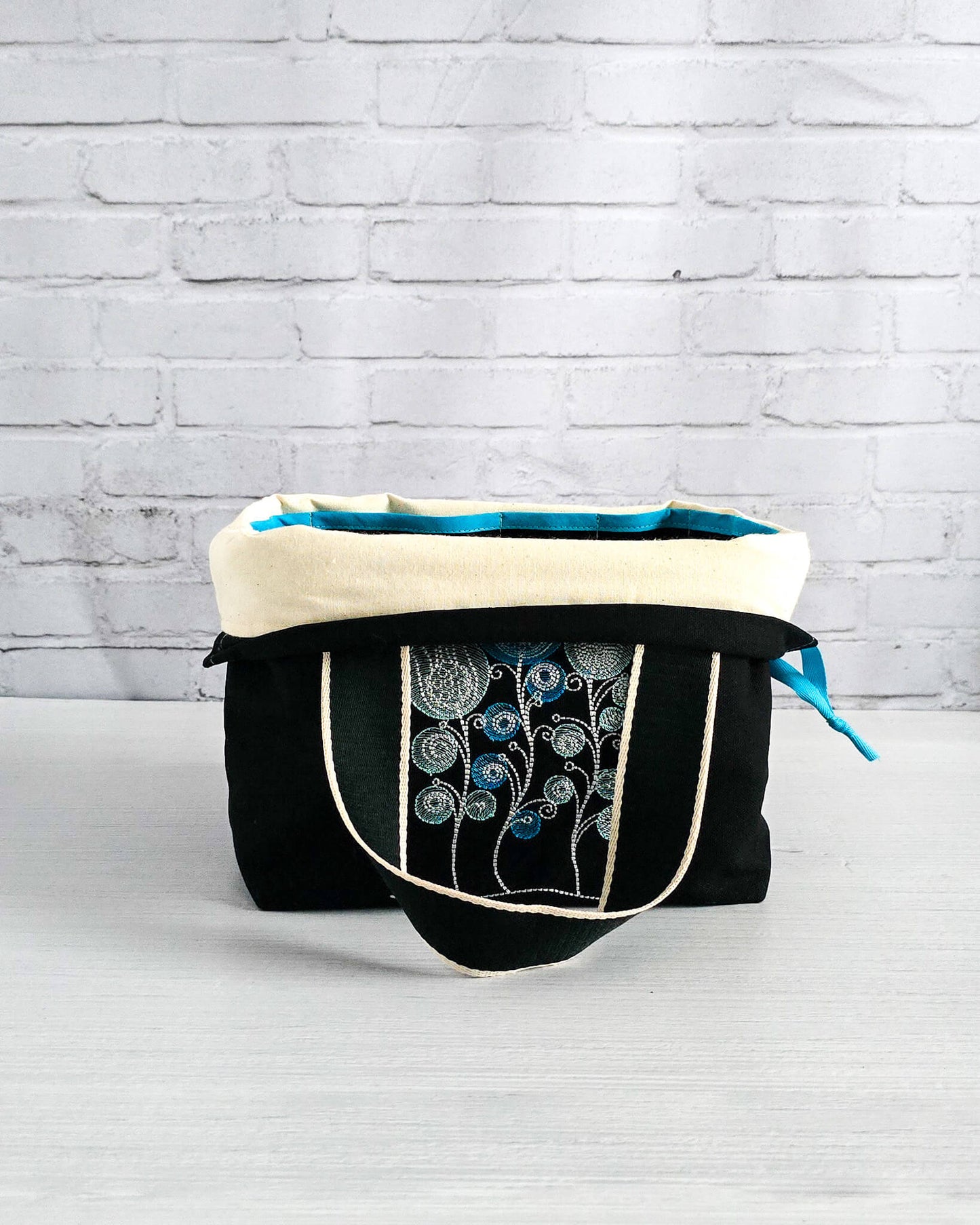 Projekttasche Alva M mit gestickten Blüten auf dunklem Canvas, handgenäht in Bayern von Nadelmikado
