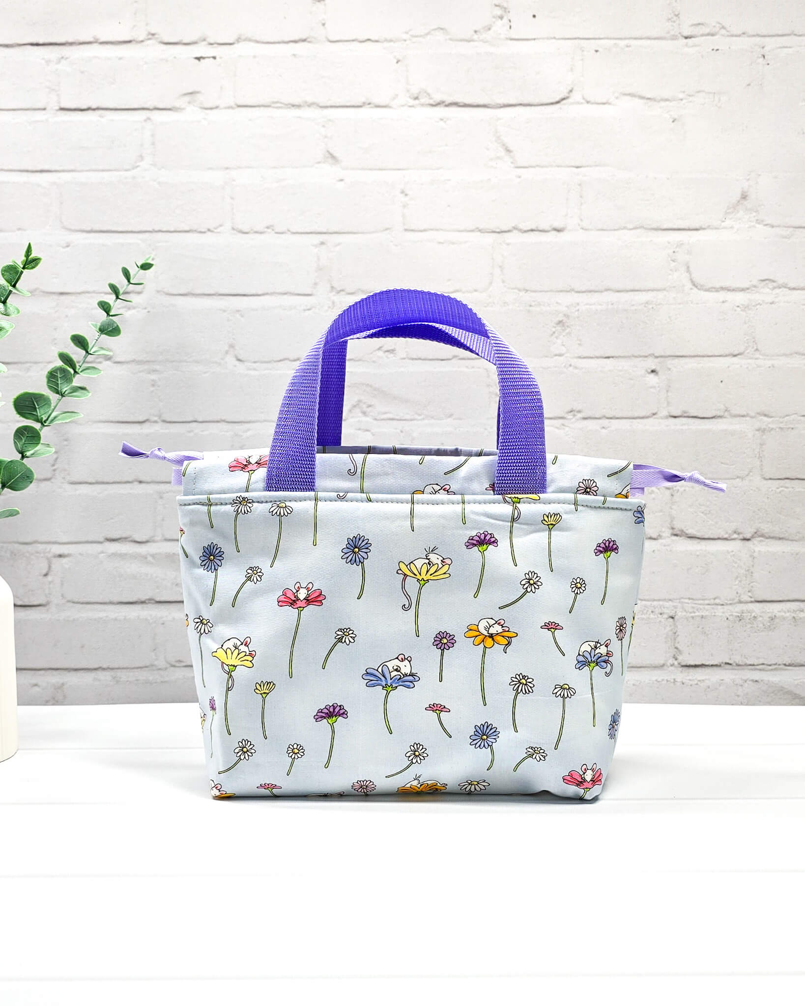 Projekttasche Alva S mit Blumenwiesenmotiv auf hellblauem Stoff, handgenäht in Bayern von Nadelmikado