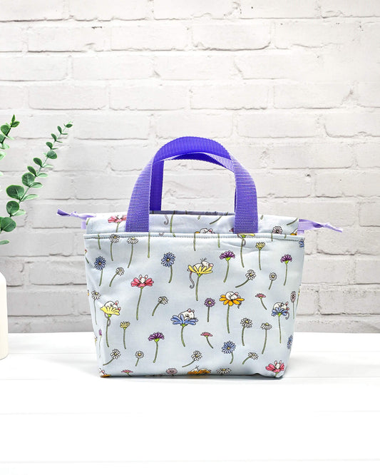 Projekttasche Alva S mit Blumenwiesenmotiv auf hellblauem Stoff, handgenäht in Bayern von Nadelmikado
