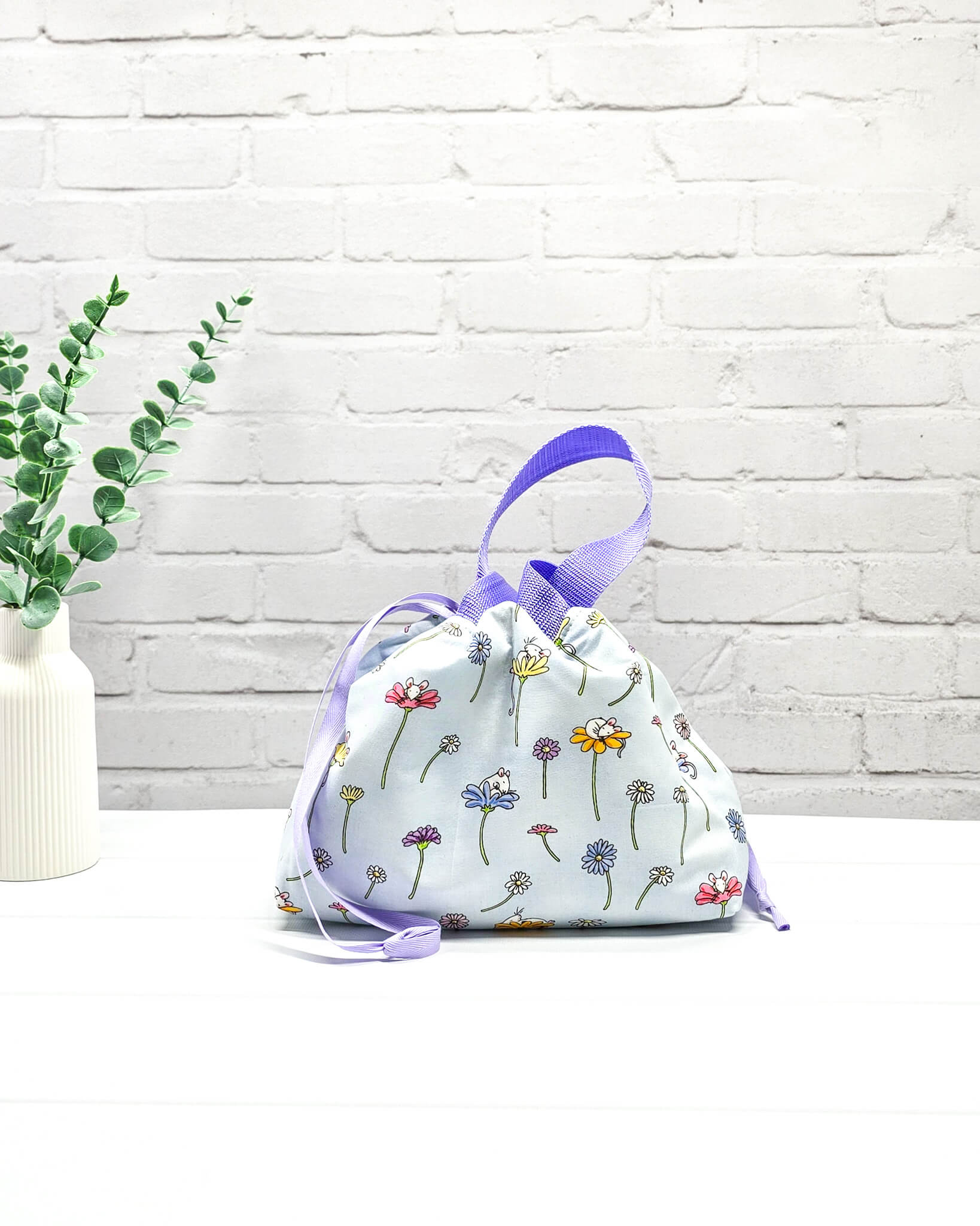 Projekttasche Alva S mit Blumenwiesenmotiv auf hellblauem Stoff, handgenäht in Bayern von Nadelmikado