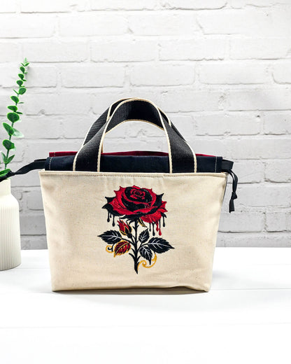 Projekttasche Alva S aus hellem Canvas mit gestickter Gothic Rose, schwarzen Henkeln und Kordelzug. Handgenäht in Bayern von Nadelmikado.