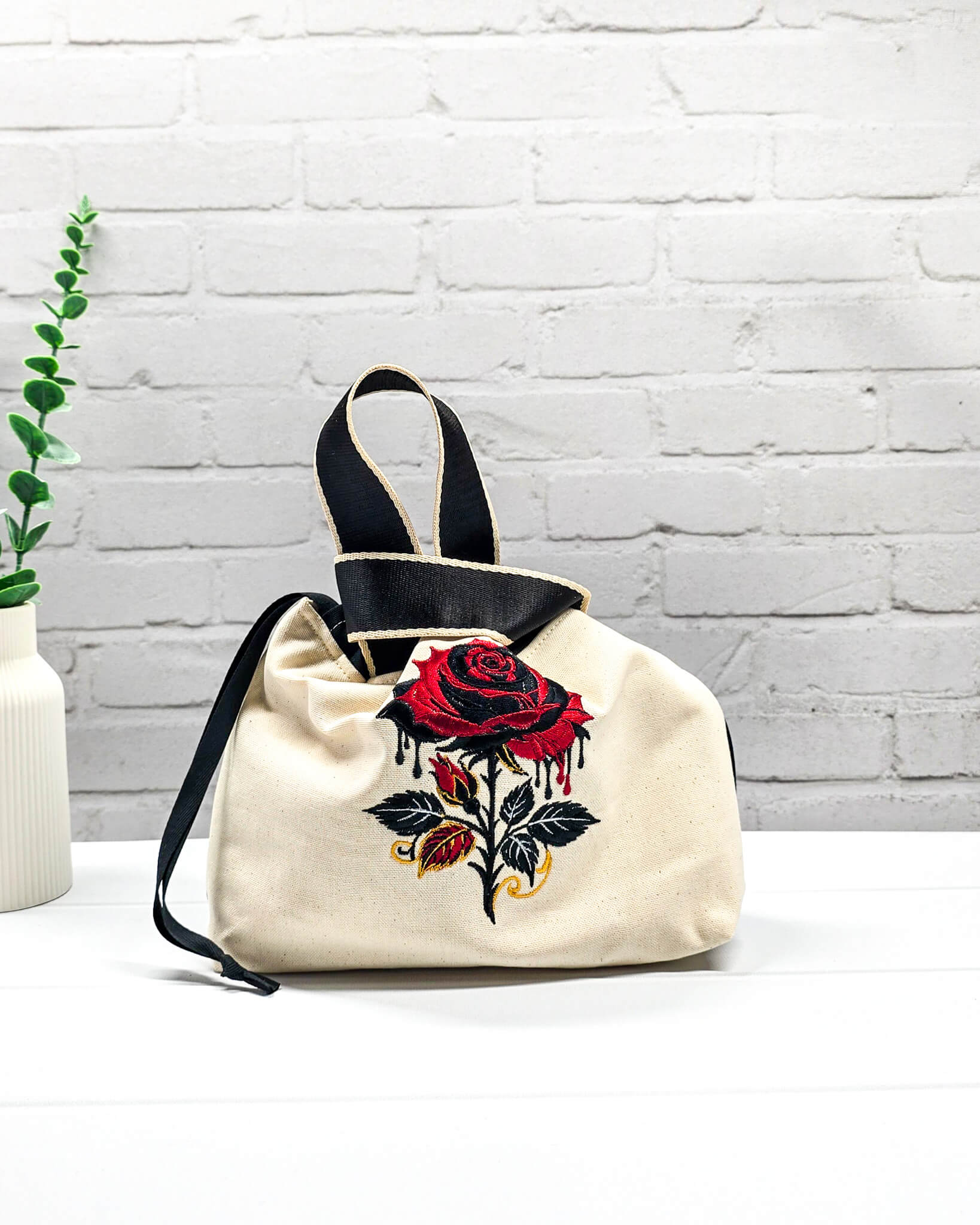 Projekttasche Alva S aus hellem Canvas mit gestickter Gothic Rose, schwarzen Henkeln und Kordelzug. Handgenäht in Bayern von Nadelmikado.