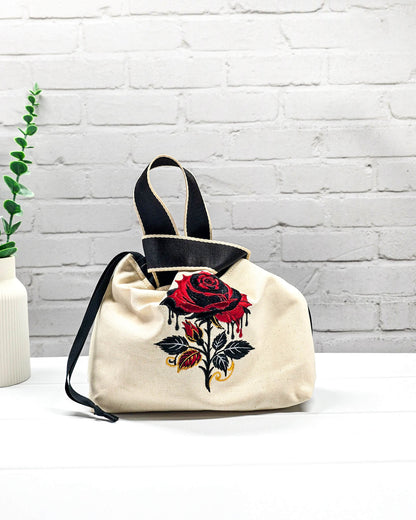 Projekttasche Alva S aus hellem Canvas mit gestickter Gothic Rose, schwarzen Henkeln und Kordelzug. Handgenäht in Bayern von Nadelmikado.
