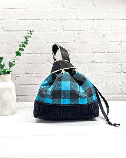 Handgemachte Projekttasche Alva in Größe S mit zwei Tragegriffen, blau-schwarzem Karomuster und einem Taschenboden aus schwarzem Breitcord. Handgenäht in Bayern von Nadelmikado. 