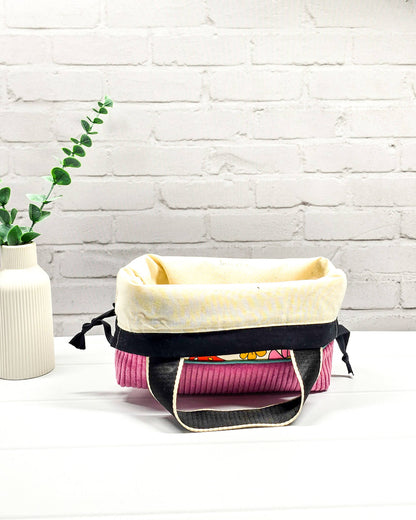 Handgemachte Projekttasche Alva in Größe S mit zwei Tragegriffen, bunten Retro-Pilzen und Blumen auf hellem Stoff und einem Taschenboden aus altrosa Breitcord. Handgenäht in Bayern von Nadelmikado. 
