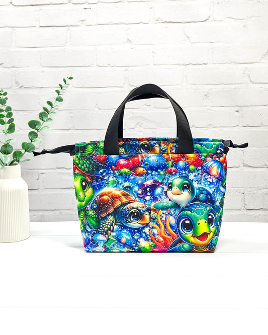 Projekttasche Alva S mit buntem Schildkrötenmotiv, handgenäht in Bayern von Nadelmikado