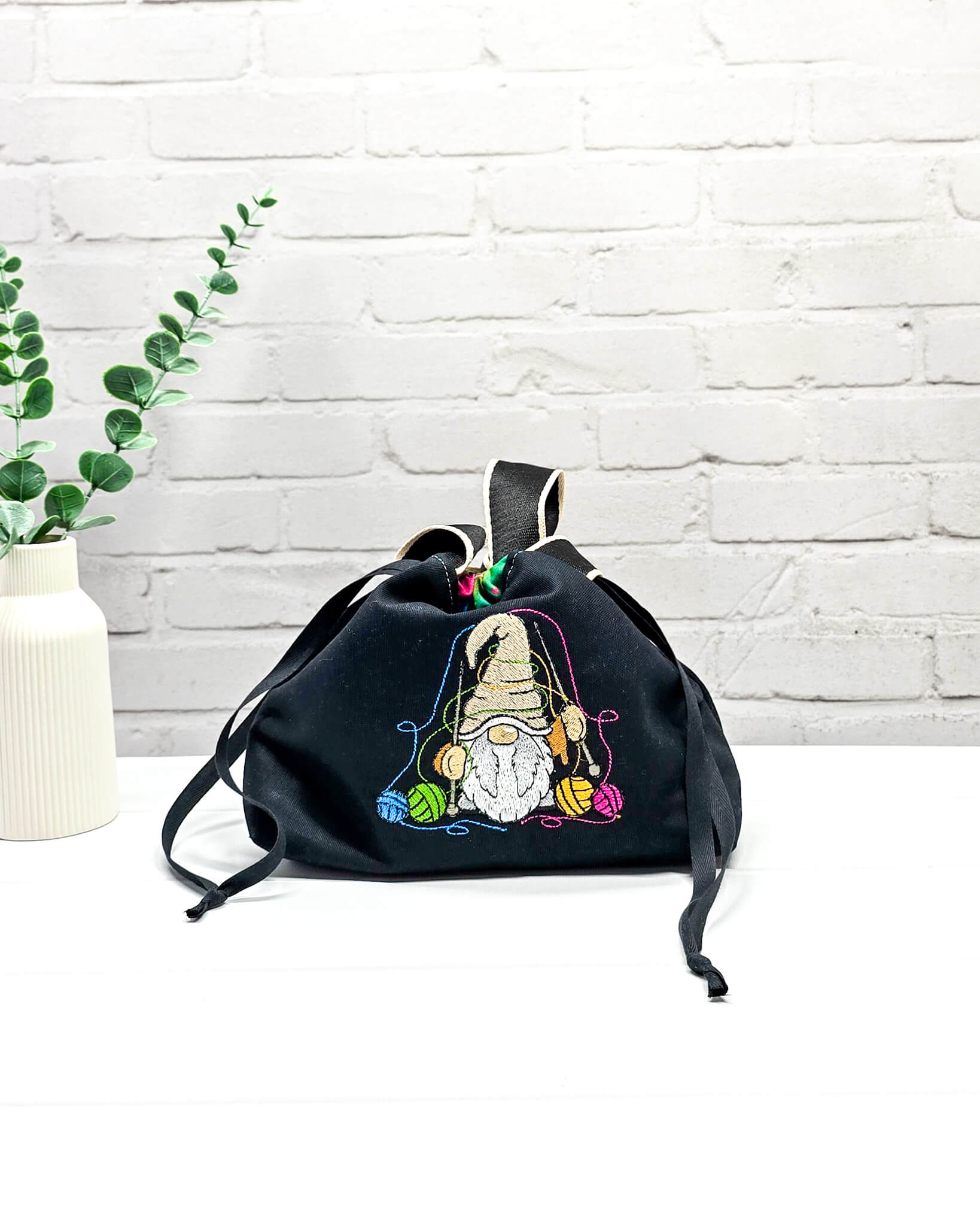 Projekttasche Alva S mit farbigem Strickwichtel auf schwarzem Stoff, handgenäht in Bayern von Nadelmikado