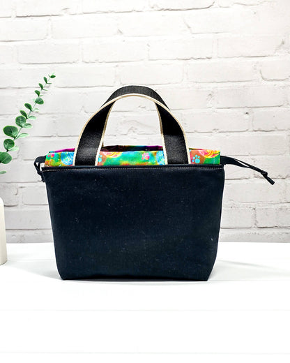 Projekttasche Alva S mit farbigem Strickwichtel auf schwarzem Stoff, handgenäht in Bayern von Nadelmikado