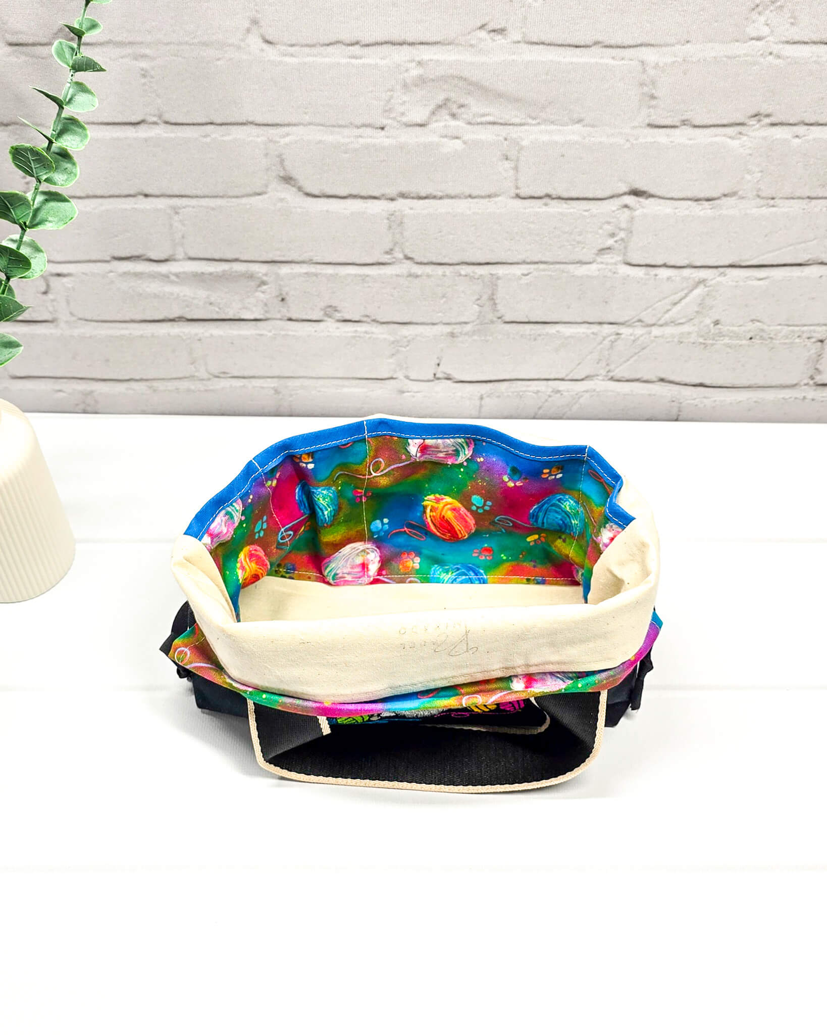 Projekttasche Alva S mit farbigem Strickwichtel auf schwarzem Stoff, handgenäht in Bayern von Nadelmikado