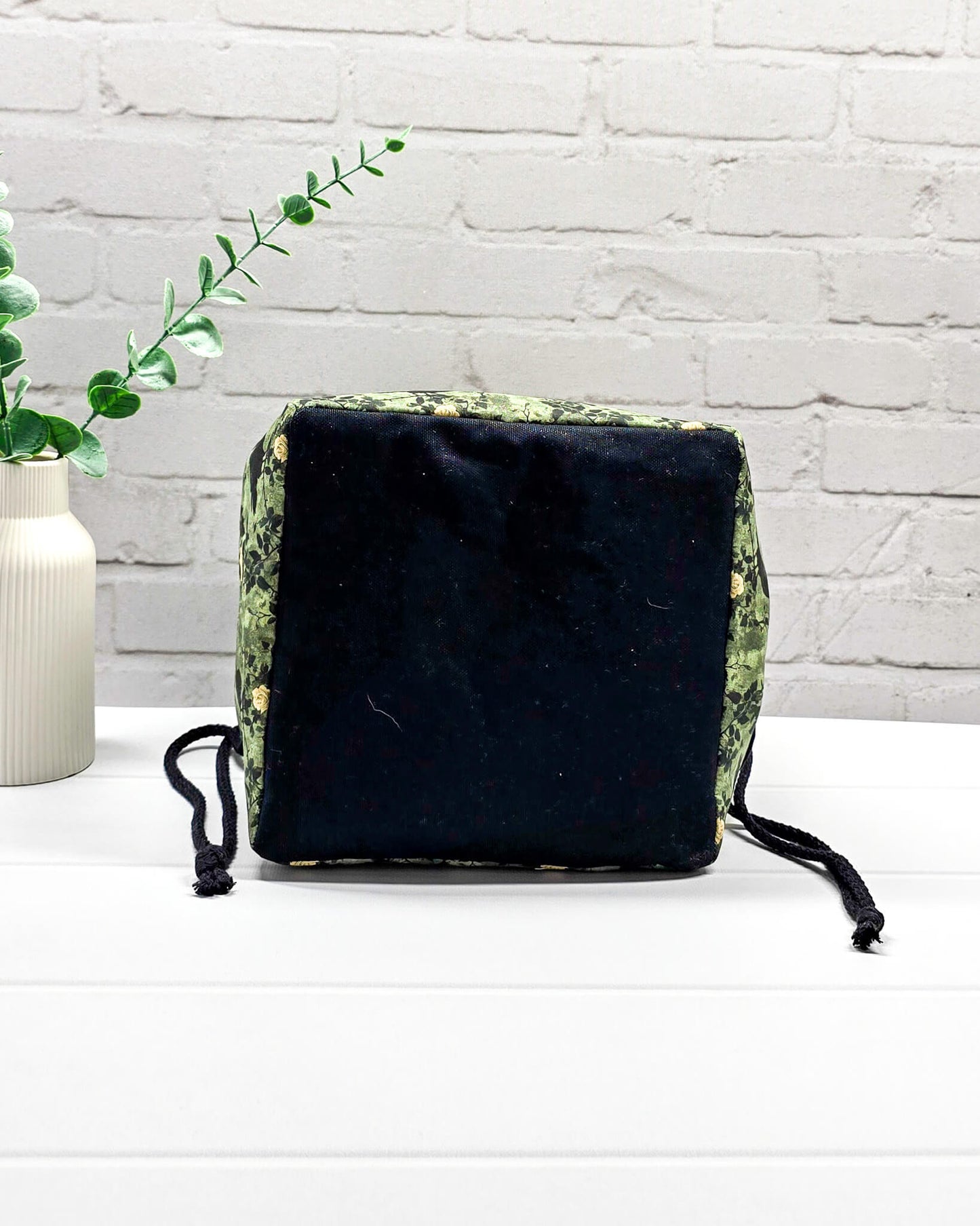 Mittlere grüne Projekttasche mit Kordelzug im Rice Bag Stil, gemustert mit Raben und Rosen, genutzt als Strickbeutel für ein Tuchprojekt mit bis zu 400g Wolle. Handgenäht in Bayern  von Nadelmikado.