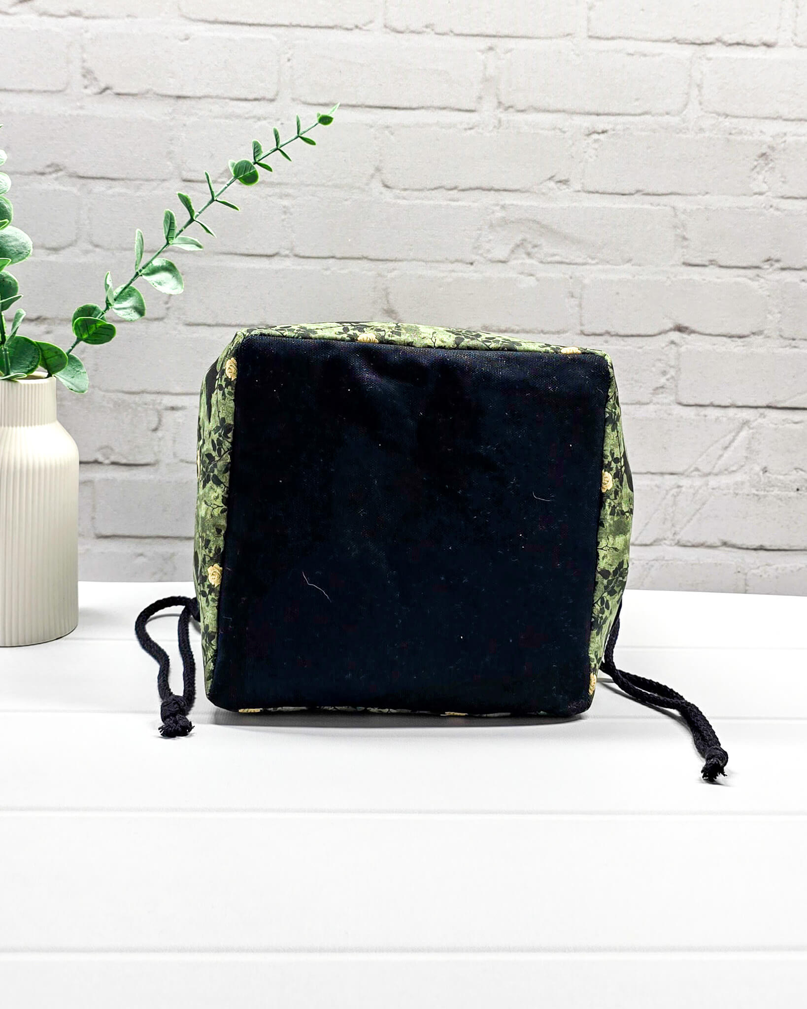 Mittlere grüne Projekttasche mit Kordelzug im Rice Bag Stil, gemustert mit Raben und Rosen, genutzt als Strickbeutel für ein Tuchprojekt mit bis zu 400g Wolle. Handgenäht in Bayern  von Nadelmikado.
