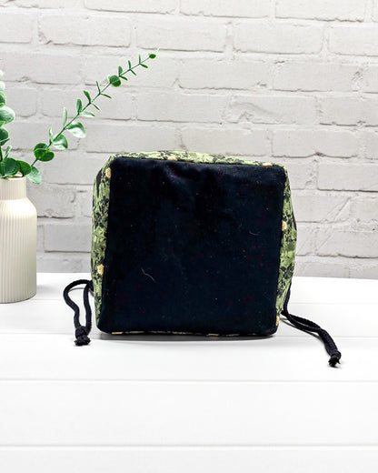 Mittlere grüne Projekttasche mit Kordelzug im Rice Bag Stil, gemustert mit Raben und Rosen, genutzt als Strickbeutel für ein Tuchprojekt mit bis zu 400g Wolle. Handgenäht in Bayern  von Nadelmikado.