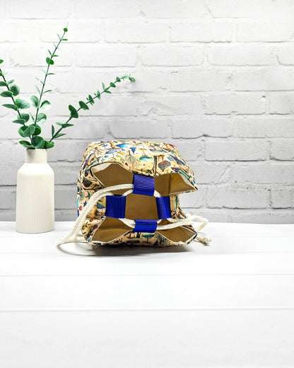 Projekttasche Aska Größe S als Rice Bag mit bunten Pilzen, kleinen Bäumen und Waldpflanzen in Blau, Türkis und Grün auf beigefarbenem Stoff. Mit heller Kordel und blauen Schlaufen. Handgenäht in Bayern von Nadelmikado.