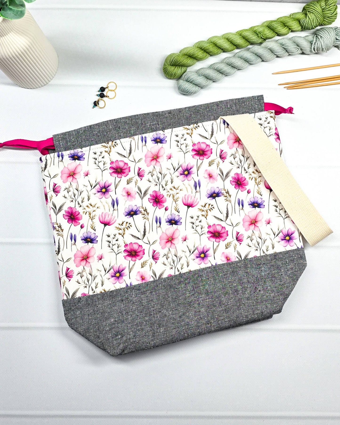 Handgenähte Projekttasche mit zartem Blumenmuster in Pink und Lila auf hellem Stoff mit graumeliertem Boden. Handmade in Bayern von Nadelmikado.