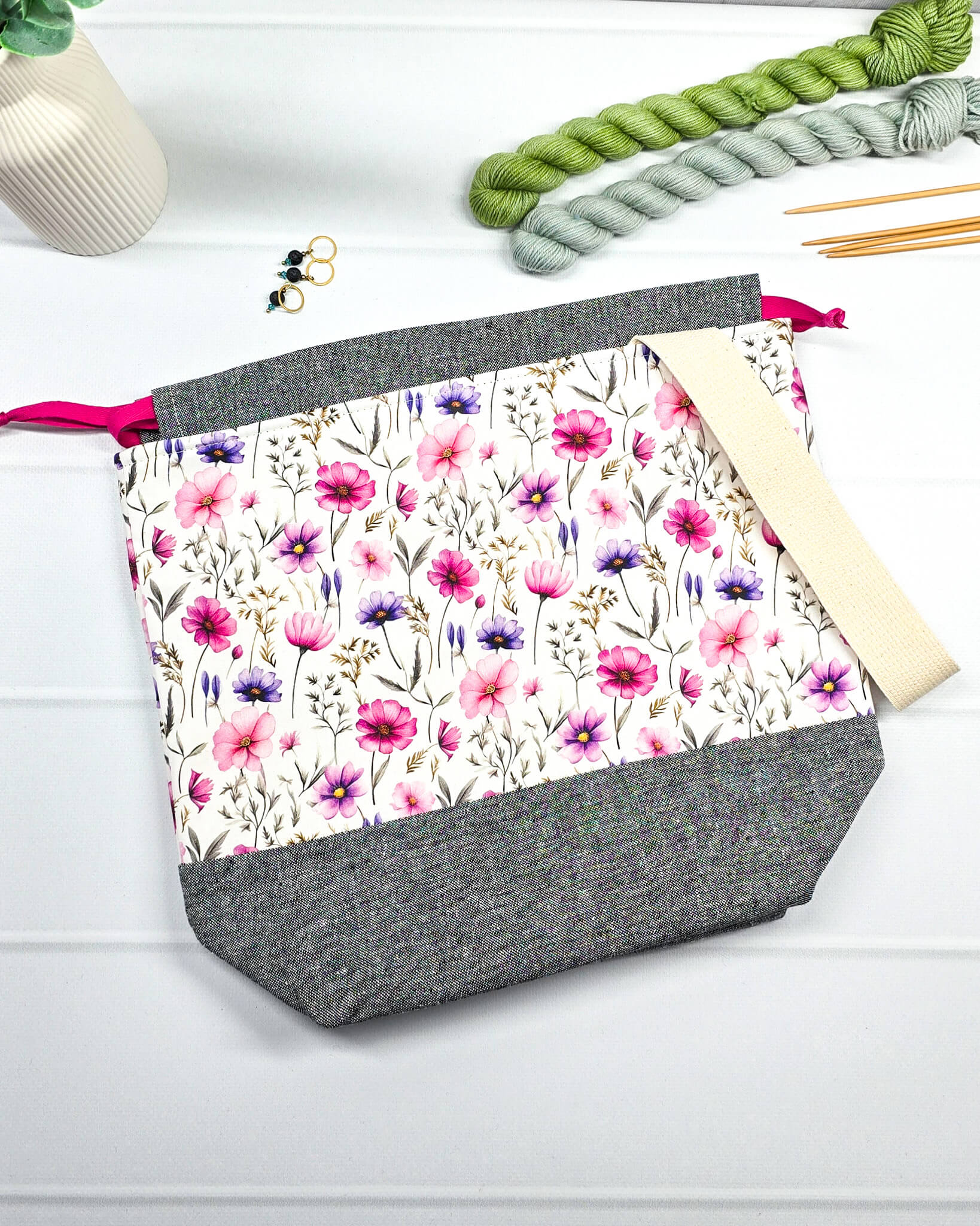 Handgenähte Projekttasche mit zartem Blumenmuster in Pink und Lila auf hellem Stoff mit graumeliertem Boden. Handmade in Bayern von Nadelmikado.