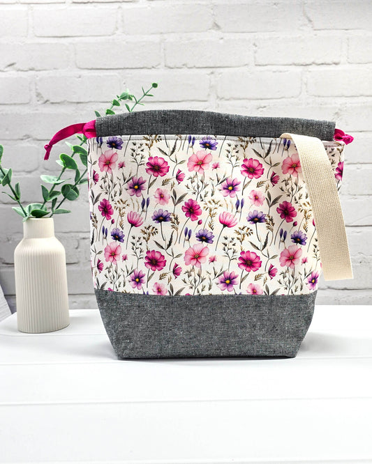 Handgenähte Projekttasche mit zartem Blumenmuster in Pink und Lila auf hellem Stoff mit graumeliertem Boden. Handmade in Bayern von Nadelmikado.